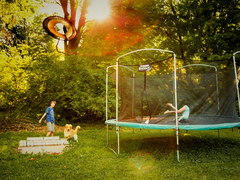Kinder spielen auf Trampolin im Garten