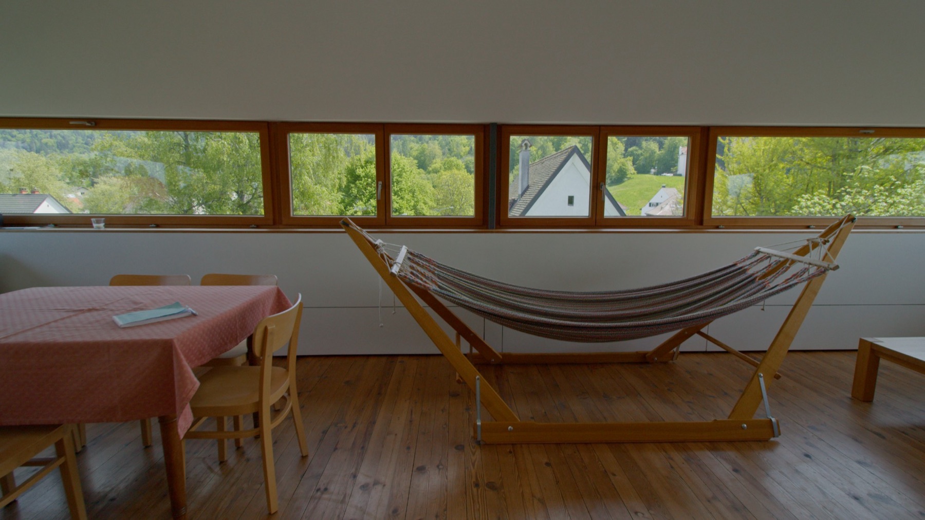 Haus Breuer – Wohnbereich mit Hängematte vor dem Panoramafenster